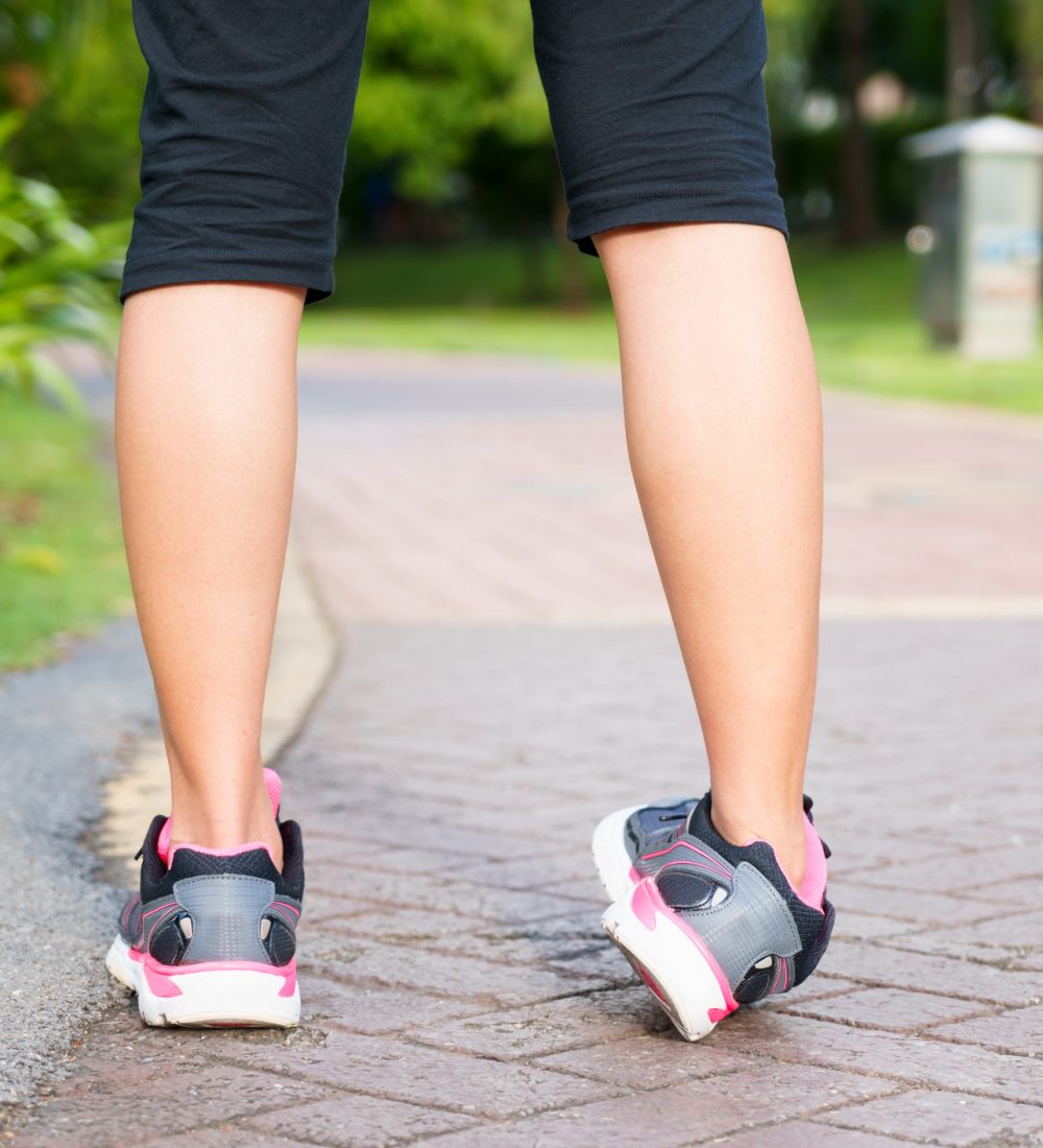 Sporty woman ankle sprain while jogging or running at park